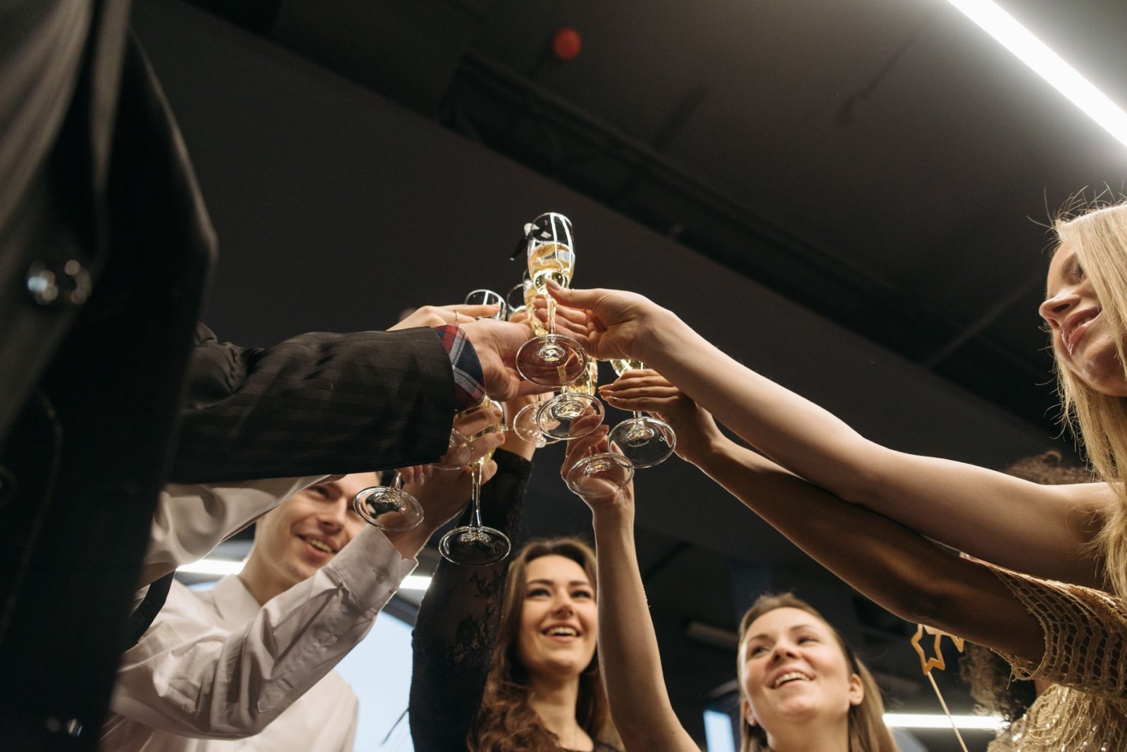 Бутылка винтажного шампанского Dom Perignon в ледяном ведре на чёрном столе, боковой свет создаёт блики на стекле, рядом два хрустальных бокала, фон размыт в глубокую темноту